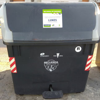 En los contenedores hay un cartel con los días de recogida de muebles y enseres